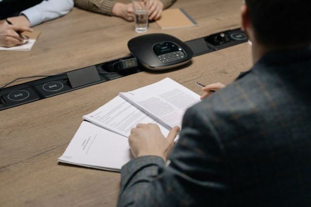 Photo d'illustration : une réunion de travail autour d'une table avec des documents