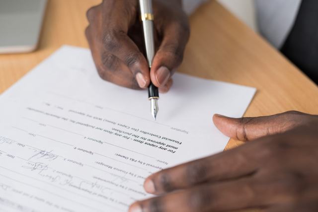 Lettre recommandée posée sur un contrat, prête à être signée